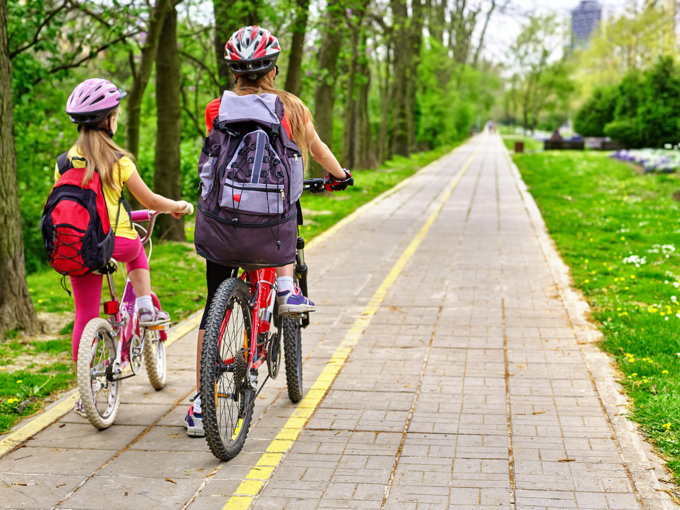 Bikes girls with rucksack cycling on bike lane.